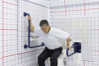 Praxistest im TOTO Technical Center in Tokio: Um die Position der Griffstangen exakt auf die Bedürfnisse körperlich eingeschränkter Personen<br />anzupassen, versetzten sich die Produktentwickler einfach in deren Lage.