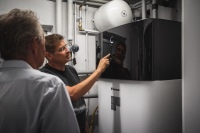 Inbetriebnahme nach zweitägiger Installation: Die Daikin Altherma 3 H HT ersetzt die 14 Jahre alte Gasheizung. Installateur Oliver Keul erklärt den Hausbesitzern die Regelung der Wärmepumpe.  