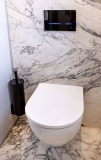 Als WCs wurden die spülrandlosen und daher reinigungsfreundlichen Keramiken der Serie Acanto von Geberit eingebaut. Die Betätigungsplatte Geberit Sigma80 überzeugte den Bauherrn vor allem durch ihr elegantes Design: Die schwarze Glasplatte funktioniert vollständig berührungslos.