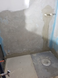 In der Wand wird hinter einer Revisionsöffnung die Membran-Pumpe angebracht. Sie ist mit einer 22-er PE-Abflussleitung mit dem Duschboard verbunden