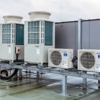 Sechs Hybrid VRF-Außengeräte mit 400 kW Kälte- und 450 kW Heizleistung sind auf einem Dach aufgestellt. Sie führen das Kältemittel über Strangleitungen zu sechs HBC-Controllern.