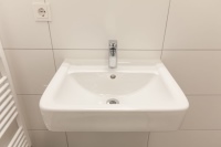 Alle 137 Bäder im Apartmenthaus Cubus130 in Frankfurt sind mit modernen Waschbecken aus der Serie Renova Plan ausgestattet. Sie zeichnen sich durch ihre geringe Breite aus – ideal für kleine Bäder. In den barrierefreien Apartments erhöht ein Unterputzsiphon die Bewegungsfreiheit.<br />Bilder: Geberit
