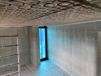 Das Betonhaus wurde mit einer Natur-Klimadecke aus Hochleistungs-Lehmmodulen ausgestattet. Durch die Schlauchleitungen strömt je nach Bedarf warmes oder kaltes Wasser.<br />Bild: Kamp C / ArgillaTherm