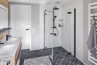 Volltreffer ins Schwarze: Die Beschlag-Duschkabine MENA, hier als klassischer Eckeinstieg mit Wandprofil, passt mit Akzenten in Schwarz Soft ideal in dieses moderne Badezimmer.<br />Bild: Kermi