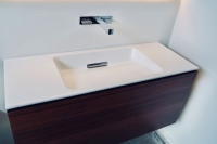 Der Waschtisch-Ablauf ist eines der Highlights von Geberit ONE: Er ist am hinteren Rand des Beckens platziert und so nicht direkt dem Wasserstrahl ausgesetzt. So bilden sich kaum Wasser- und Kalkrückstände. Der Waschtisch wird mit der ONE Armatur kombiniert.