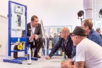Interessierte Besucher unterhalten sich mit dem Geberit-Experten über den Unterputz-Spülkasten der Zukunft, inklusive neuem Spülventil Typ 212 sowie der neuen Elektro- und Kommunikationsanschlussdose.