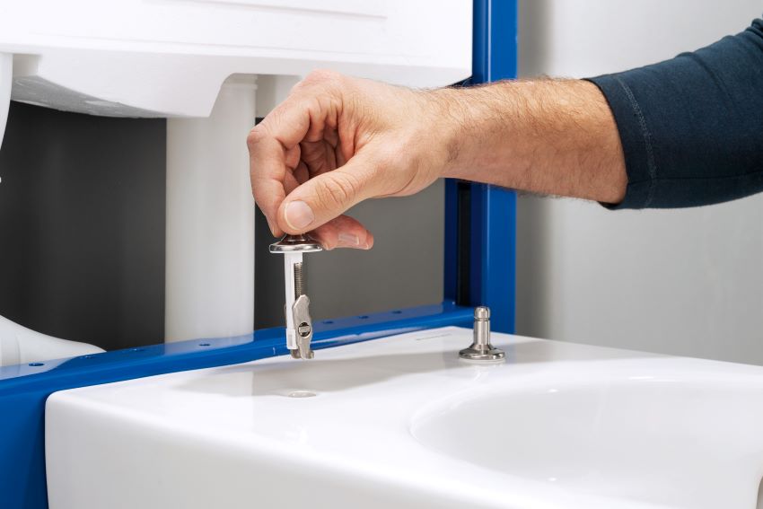 Der Kippdübel, mit dem der WC-Sitz an der Keramik befestigt...