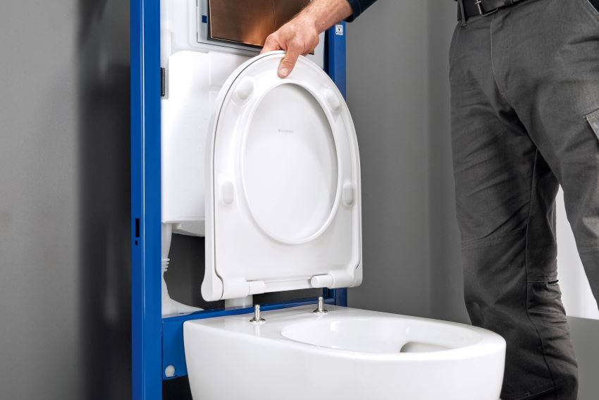 Indem der WC-Sitz um 90 Grad nach oben aufgeklappt...