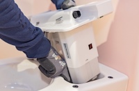 Der Monteur setzt die Technik-Einheit in einem der 18 Geberit AquaClean Sela Dusch-WCs ein. Sie kann problemlos von oben in die WC-Keramik eingesetzt und ebenso mühelos wieder entfernt werden, was die Wartung besonders unkompliziert gestaltet.