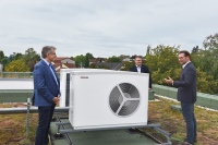 Frank Nolte (links), Vorstandsvorsitzender der Wohnungsgenossenschaft, mit Installateur Jürgen Niedereichholz (Mitte) von der SHK-Firma Minnhard Meewes GmbH und Marc Rakowske (rechts) von STIEBEL ELTRON an den beiden Luft-Wasser-Wärmepumpen auf dem Dach.<br />Bilder: STIEBEL ELTRON<br /><br /><br />