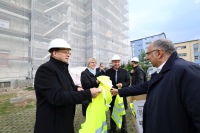 Mit Warnweste und Helm: Reza Tehrani verteilt die Sicherheitsutensilien an die Teilnehmer des Presserundgangs. Bilder: NHW / Andreas Fischer