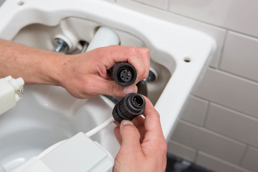 Die Anschlüsse für Strom und Wasser sind in der WC-Keramik...