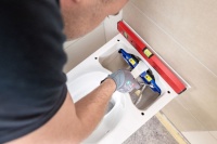 Die WC-Keramik wird komfortabel von oben an der Wand montiert. Verschraubung sowie Strom- und Wasseranschlüsse sind dabei gut zugänglich.