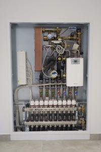 Die dezentralen Wohnungsstationen integrieren einen elektronisch gesteuerten Durchlauferhitzer (18 - 21 kW), Wärme- und Wassermengenzähler sowie die Verteilereinheit für die Flächenheizung.