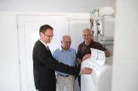 Heiko Gilster, Produktmanager bei BRÖTJE (links) und Frank Arlt (rechts) von der G.U.T.-Gruppe erläutern Bauunternehmer Georg Kleinert (Mitte) die Funktionen der Wärmepumpe.