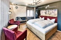 Im Themenzimmer von Daniel Tress zeigt eine großformatige Aufnahme über dem Bett einen stilvoll gedeckten Tisch.     <br />Bild: Emoton