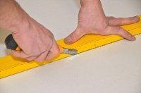 Zum Zuschnitt werden die Platten mit einem Cuttermesser eingeritzt und anschließend einfach gebrochen.<br />Bild: MIPROTEC