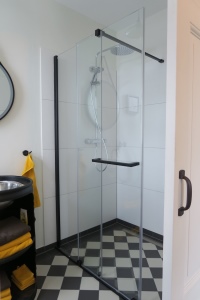 Schickes, minimalistisches Design von Duschwelten: Die Schiebetür mit der Rollenführung unten setzt in diesem Bad einen starken Akzent.<br />Bild: Duschwelten
