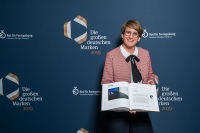Yvonne Dallmer, Geschäftsführerin der Dallmer GmbH + Co. KG, zeigt stolz den Eintrag ihres Unternehmens in der Publikation des Rats für Formgebung. <br /><br />Bild: Rat für Formgebung/Martin Diepold<br />