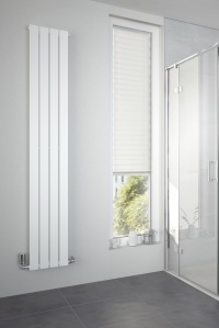 Der in Lamellen gehaltene Designheizkörper Alto fügt sich in der Standardfarbe Weiß perfekt ins Bad ein. 