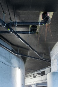 Für die Dachentwässerung des Axel-Springer-Neubaus setzen die Fachleute des Haus- und Versorgungstechnikspezialisten HVT GmbH das System Geberit Pluvia ein, das mit Unterdruck arbeitet und pro Einlauf bis zu 25 Liter Wasser pro Sekunde vom Dach befördert. PE Rohre transportieren das Wasser bis in die Zisterne im Untergeschoss.<br />Bilder: Geberit