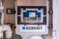 Unter der Abdeckung befindet sich ein QR-Code, mit dem die Geberit SetApp zur Bedienung der Hygienespülung auf ein Smartphone oder Tablet heruntergeladen werden kann. Zusätzlich finden sich hier Testschalter, Seriennummer und Leuchtdioden, die aufzeigen, ob die Hygienespülung korrekt funktioniert.  