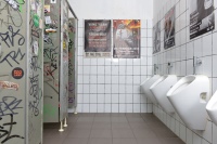 Vor der Sanierung: Die Sanitäranlagen sind abgenutzt und mit Druckspüler-Urinalen in die Jahre gekommen.