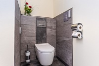 Mit dem Dusch-WC AquaClean Sela von Geberit überrascht der Landgasthof Hessenmühle seine Gäste. Schickes Detail: Die Spülauslösung von Geberit – Sigma50 mit Schieferplatte – fügt sich hervorragend in die Wandgestaltung ein.