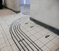 Im ersten Schritt der Fächenheizungsinstallation erfolgte die Verlegung der x-net C12 Tackerplatten in den Schulräumen sowie der x-net connect base plus Platten in den Fluren. Die durchlaufenden Zuleitungen vom Verteiler in die jeweiligen Räume wurden mit Hilfe des x-net Heißschneiders connect in die Systemplatten x-net connect base eingelassen und somit gezielt unter dem Estrich hindurchgeführt. 