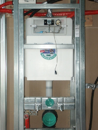 „VariVIT“ WC-Element mit Blick ins Innenleben des „Sanicontrol“-Spülkastens. Zu sehen sind unter anderem der Eckventilanschluß sowie der Elektromagnetheber mit dem  Steuerkabel, das  an die Elektronik der WC-Spülautomatic „Sanicontrol 840“ angeschlossen wird und für die Auslösung der Glocke sorgt.