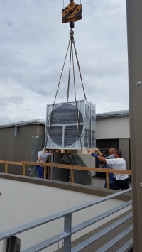 Komplizierter Transport: Mit vereinten Kräften haben die Installateure die Geräte durch einen Hintereingang im obersten Stock zur Lüf-tungsanlage unter dem Dach geschafft.