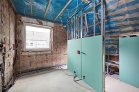 Bauphase: Die Vorwandinstallationselemente werden aufgebaut und sind hier bereits teilweise verplankt.