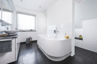 Die überzeugende Verwandlung: Eine trennende Vorwand gliedert architektonisch stilvoll den Raum und nimmt auf der einen Seite die Badewanne und auf der anderen Seite Dusche sowie im hinteren Bereich das WC auf.<br />Bilder: Viega GmbH & Co. KG