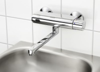 Eine kurze Handbewegung vor dem gut sichtbaren Sensorfenster löst bei der neuen, elektronischen WASH-S Wandbatterie mit Thermostat den Wasserfluss für die voreingestellte Fließzeit aus. Bild: Franke Aquarotter GmbH<br />