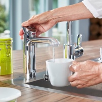 Beim Druck auf die linke Taste fließt kochendes Wasser aus der Armatur.