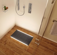 Durch das vielseitig einsetzbare LED-Leuchtprofil bietet ACO Lightline Pro individuelle Möglichkeiten zur Licht- und Bodengestaltung in Badezimmern. Hier ist es verlegt entlang der bodenebenen Entwässerungslösung ACO Walk-In, Farbe coal. <br />Bildquelle: ACO Passavant GmbH