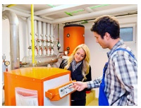 Handwerker stellt Brennwertkessel ein. Bild: Co2online