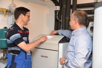 Firmeninhaber und Hausbesitzer Meinolf Drees mit Stiebel-Eltron-Planer Berater Marcus Schüttler an der Erdreich-Wärmepumpe WPF 16.