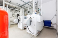 Doppeltes Lottchen: Da die Produktionshalle ebenfalls über die neue Heizungsanlage versorgt werden soll, wurden in der Lackierhalle gleich zwei STRATON XL 150 Öl-Brennwertkessel von ELCO eingeplant. Sie ergänzen die Luft-Wasser Wärmpumpe. 