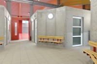 Der runde Eingangsbereich dient mit den wandbefestigten Sitzgelegenheiten als Treffpunkt für Schulklassen und Vereine.