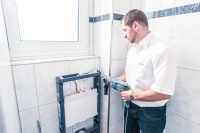 Ist die alte WC-Anlage demontiert, werden die Löcher für den Grundrahmen gebohrt, die Dübel gesetzt und die Schrauben etwa einen Zentimeter in die Wand gedreht.