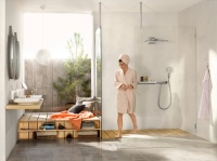 Glas und Wasser als natürlich Partner im Bad: Die Kopfbrause Rainmaker Select und die ShowerTablet Select Ablagen des Badspezialisten hansgrohe integrieren dank hochwertige Glasoberflächen das Baddesign harmonisch in die Architektur.<br />Bild: Hansgrohe