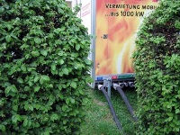 Unauffällig durch das Gebüsch verlaufen die flexiblen Verbindungsleitungen von der Mobilheizzentrale zum Heizraum des Gebäudes, ...
