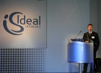 Paul Frankish, EMEA Produktmanager Möbel & Accessoires, vor dem neuen Logo Ideal Standard Internationals.