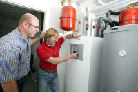 Ex-Rennfahrer Joachim Winkelhock (rechts) heizt mit Erdwärme. Installateurmeister Selami Sen von Sen Haustechnik in Waiblingen hat seinen prominenten Bekannten von Erdwärme als alternativer Energiequelle überzeugt. Foto: Junkers