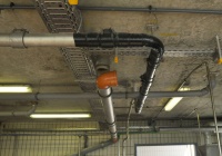 Unter der schwarzen Umwicklung liegen die Spulenpaare, die das elektromagnetische Feld zur Bildung von Nanokernen im Klärschlamm aufbauen. Insgesamt sind in Winterhausen um die DN 100-Rohrleitung sechs Doppelspulen installiert. Fließgeschwindigkeit des Klärschlamms 3 l/s.