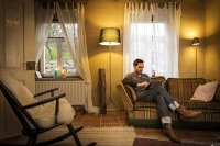Thomas M. Held gemütlich im Wohnzimmer mit dem Tablet , auf dem die Daten seiner Wärmepumpenanlage abgerufen und Einstellungen verändert werden können. <br />Bilder: STIEBEL-ELTRON