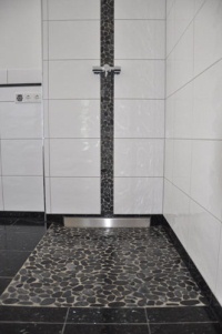 Saubere Lösung für ein Baddesign mit individueller Note: Die „Terso-WALL“-Duschrinne zur Linienentwässerung trug dazu bei, dass die elegante Kieseloptik der Fliesen nicht durchbrochen wurde. Bilder: Mepa