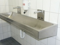 Funktion und Design auf einem Nenner: Edelstahlwaschbecken mit den infrarotgesteuerten Wandauslaufarmaturen „Saniontrol T622“.