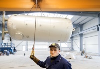 Anlagenmechanikermeister Falko Terlecki dirigiert per Fernbedienung den Kran, der den großen Behälter auf den Lkw bugsiert. Dank erweiterter Halle ist jetzt noch mehr Platz für noch mehr Behälter, die damit schneller ausgeliefert werden können. Bilder: Steffen Unger